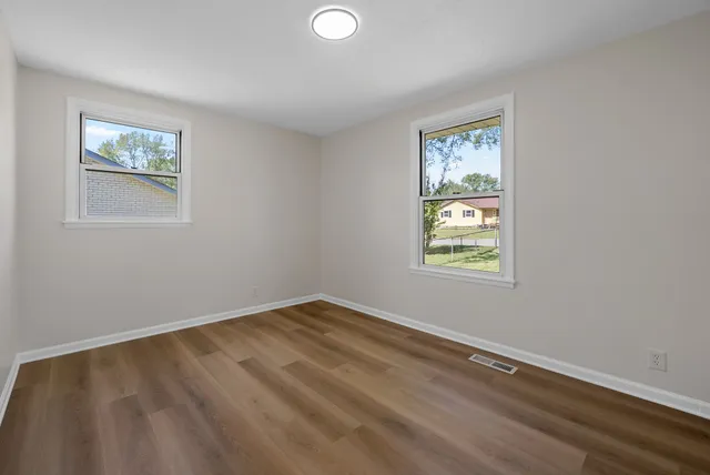 a view of an empty room with a window and closet
