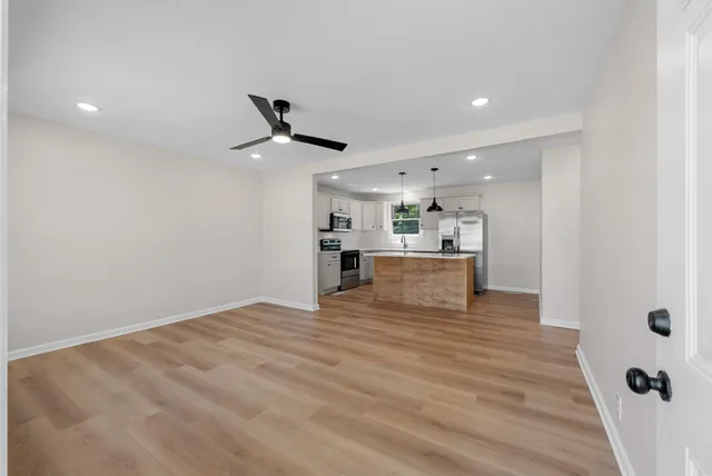 a view of a kitchen with a sink and dishwasher a refrigerator with wooden floor