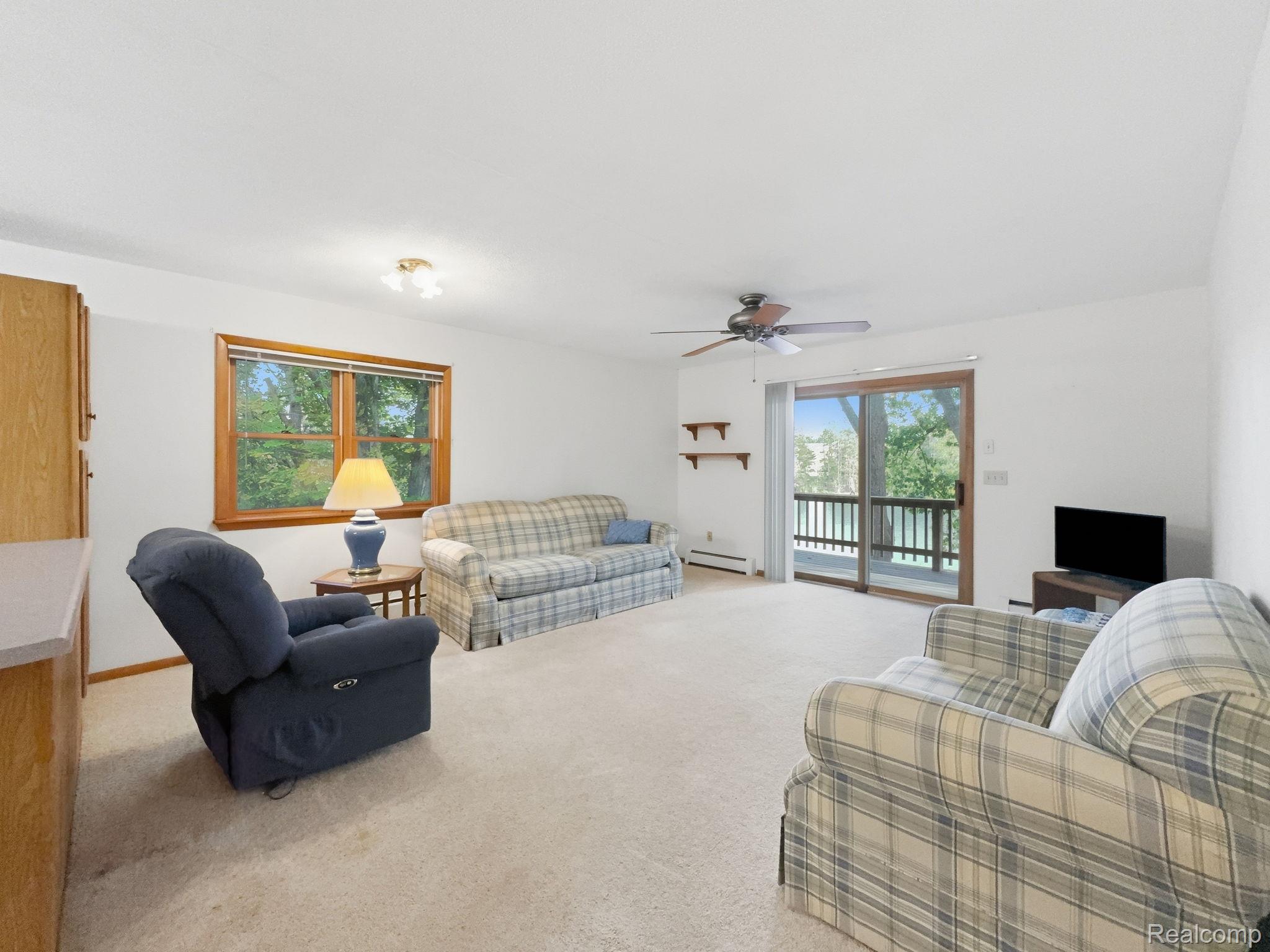 2259 Kassuba Road Gaylord, MI 49735 - Photo 10 of 46 Carpeted living space with a large window, sliding glass door, and ceiling fan.