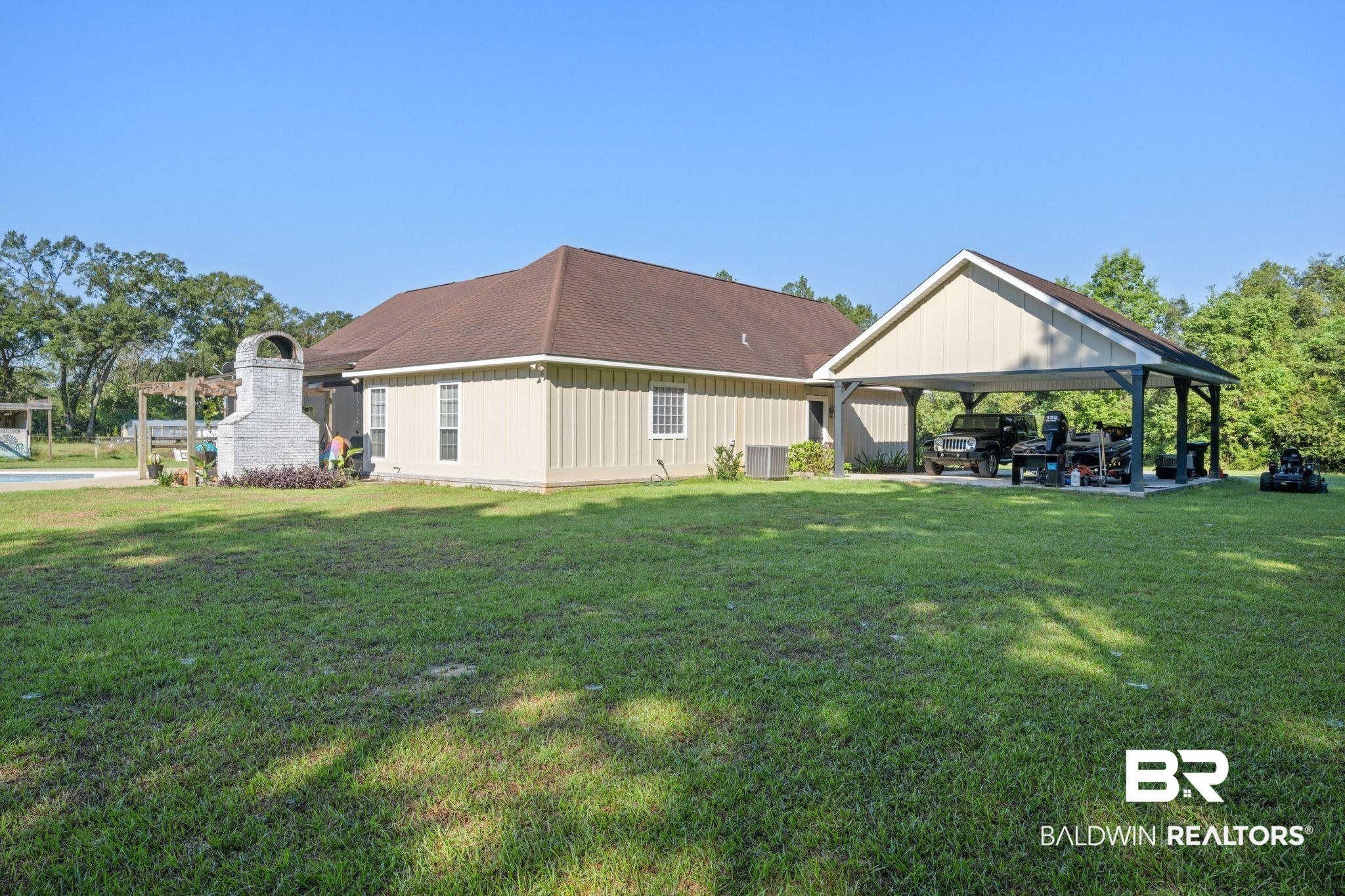 15635 North A N Brady Road Bay Minette, AL 36507 - Photo 41 of 51 View of side of property with central AC, a yard, and a carport
