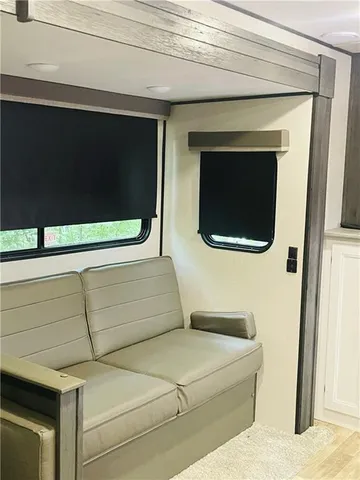 a living room with stainless steel appliances furniture and a window