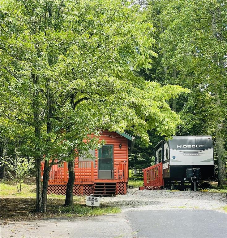 95 Hill Crest Court Cleveland, GA 30528 - Photo 2 of 26 a sign board with a bench and trees