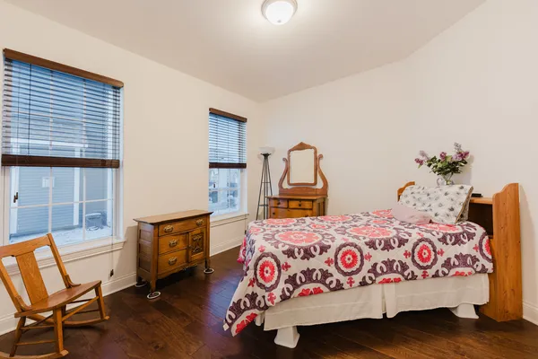 a bedroom with a bed and a dresser next to a window