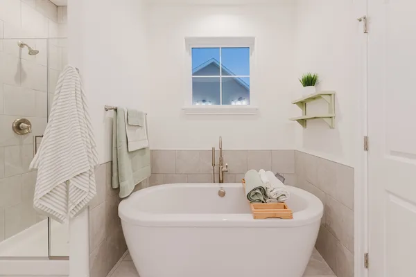 a bathroom with a tub a window and mirror