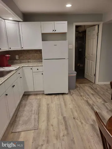 a kitchen with granite countertop white cabinets and white appliances