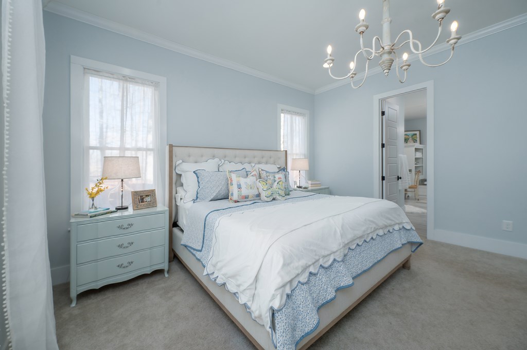 1652 Pierce Road Waverly Hall, GA 31831 - Photo 30 of 51 a bedroom with a large bed and a chandelier