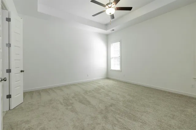 an empty room with a window and a fan