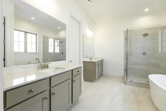 a bathroom with a double vanity sink toilet mirror and bathtub