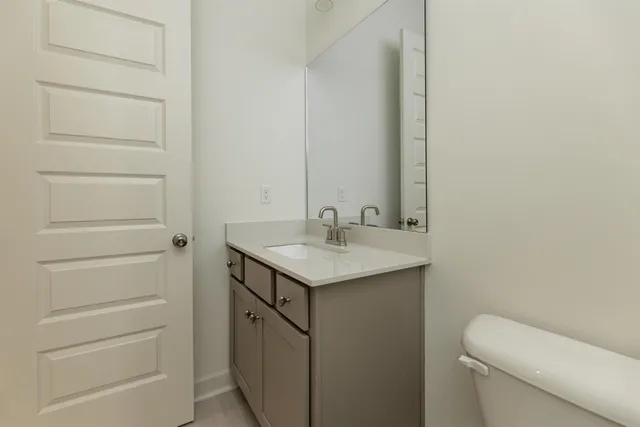 a bathroom with a sink a toilet and a mirror