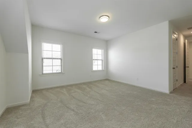 an empty room with windows and closet