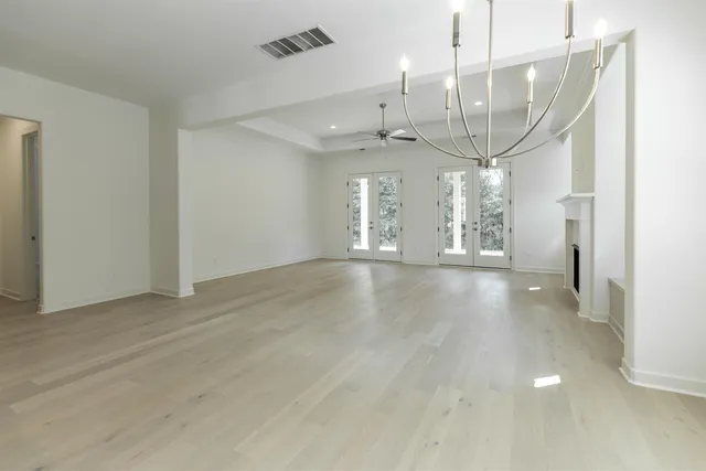 an empty room with wooden floor and outdoor view