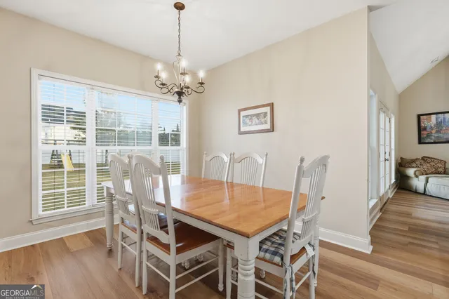 a view of a kitchen with kitchen island granite countertop a large counter top space a sink stainless steel appliances and cabinets