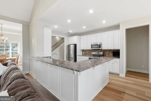 a kitchen with granite countertop a refrigerator stove top oven and sink