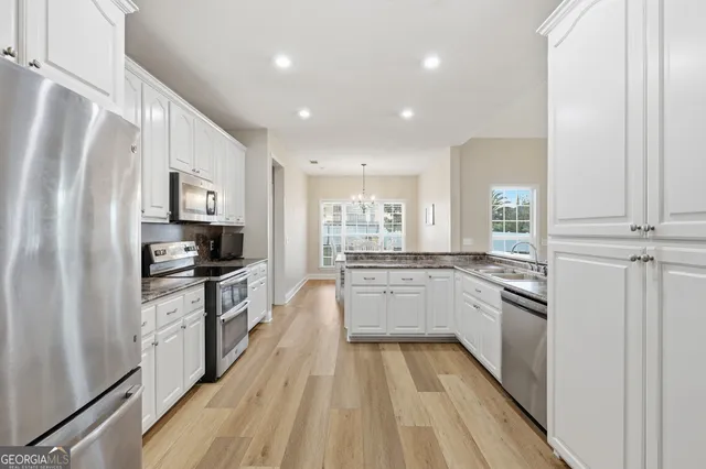 a kitchen with granite countertop a sink cabinets and stainless steel appliances