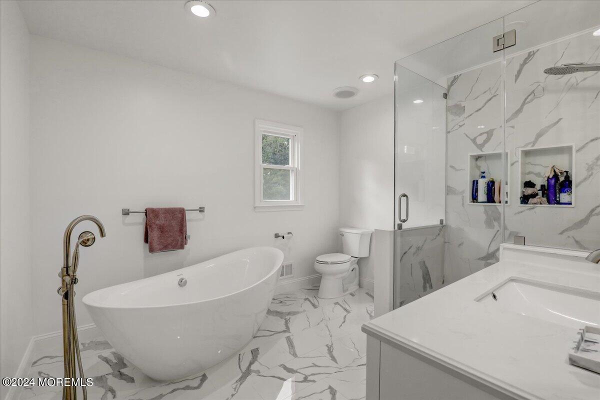 61 Apache Drive Manalapan, NJ 07726 - Photo 23 of 37 a bathroom with a sink a toilet and shower