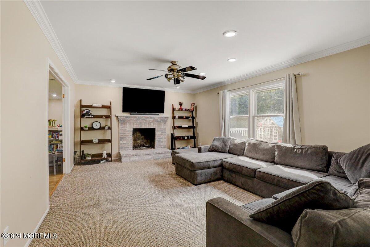 61 Apache Drive Manalapan, NJ 07726 - Photo 7 of 37 a living room with furniture a fireplace and a flat screen tv