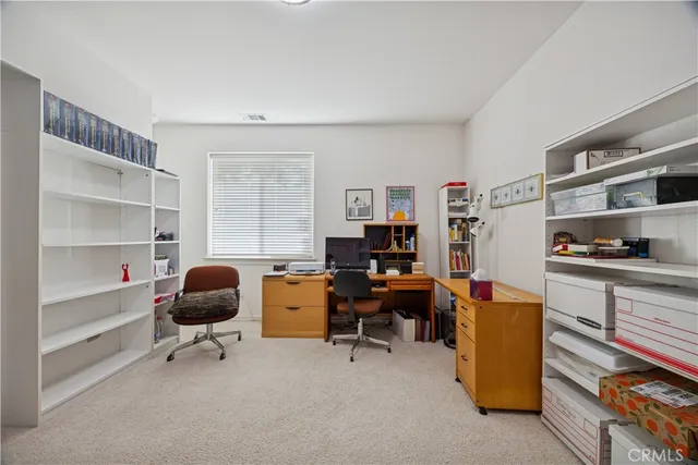 a view of a workspace with furniture and a window