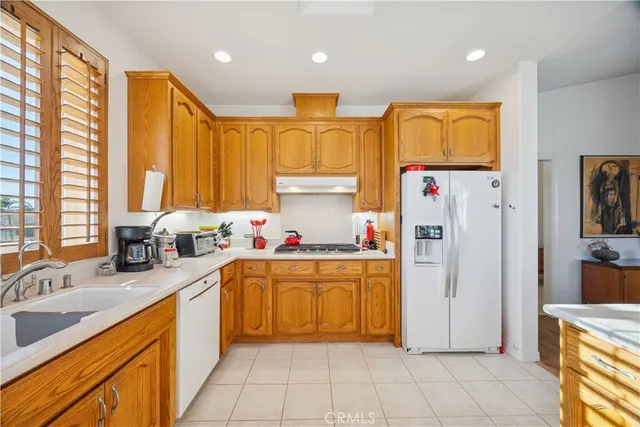 a kitchen with stainless steel appliances granite countertop a sink and a refrigerator