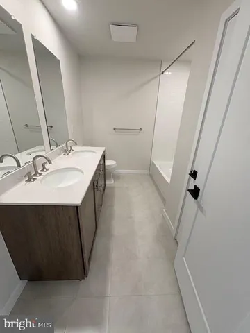 a bathroom with a sink a toilet and a mirror