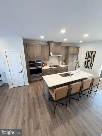a kitchen with a dining table chairs and wooden floor