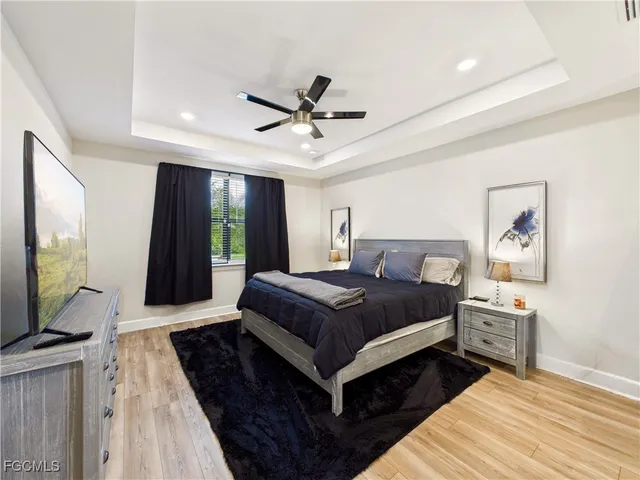 a bedroom with a bed lamp on desk and a window