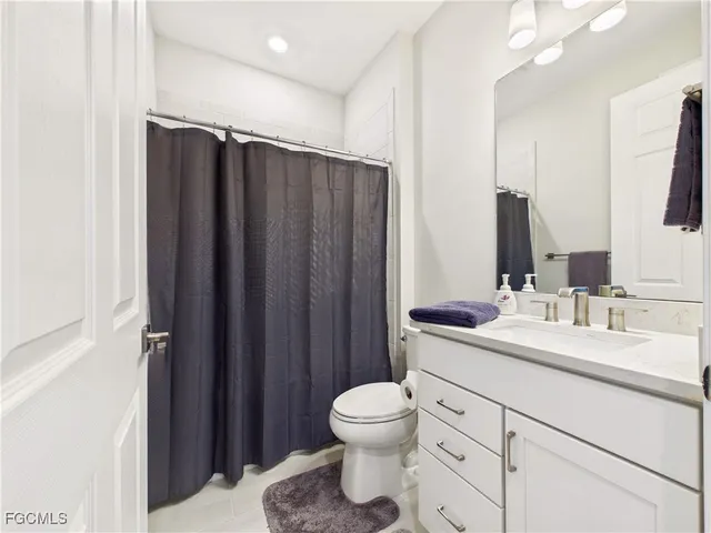 a bathroom with a double vanity sink toilet and mirror