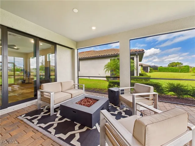 a living room with patio furniture and a floor to ceiling window