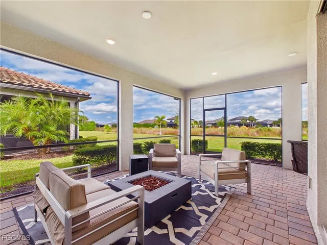 a living room with patio furniture and a floor to ceiling window