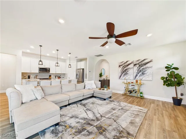 a living room with furniture kitchen view and a potted plant