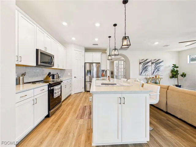 a large kitchen with kitchen island a sink a counter space and stainless steel appliances