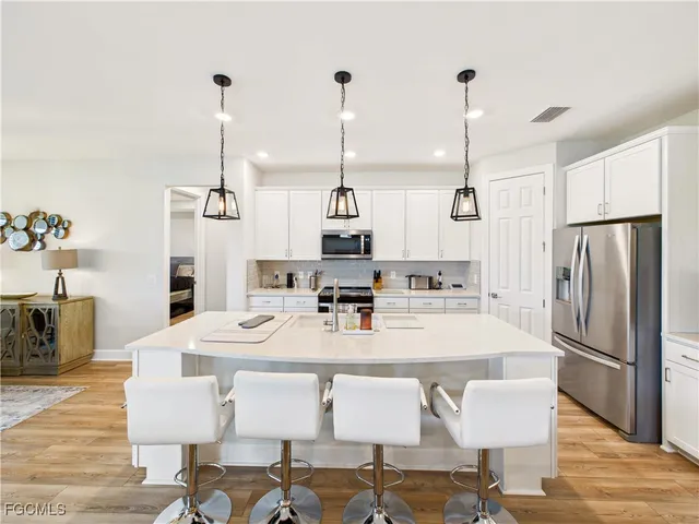 a large kitchen with a table chairs refrigerator and stove