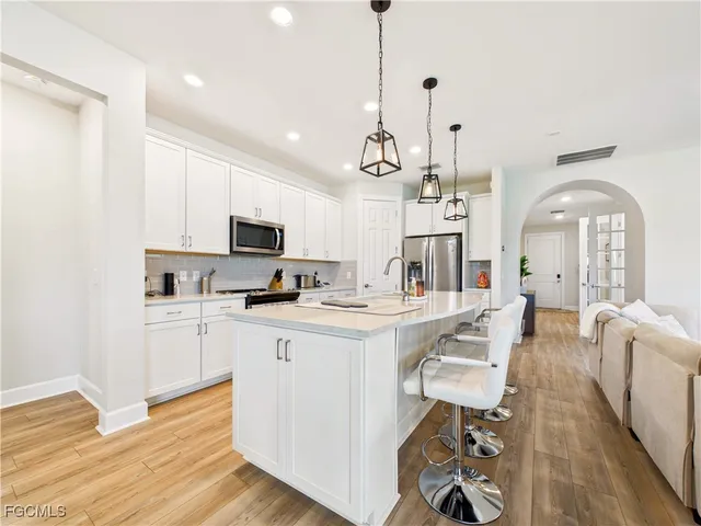 a kitchen with stainless steel appliances kitchen island granite countertop a sink and cabinets