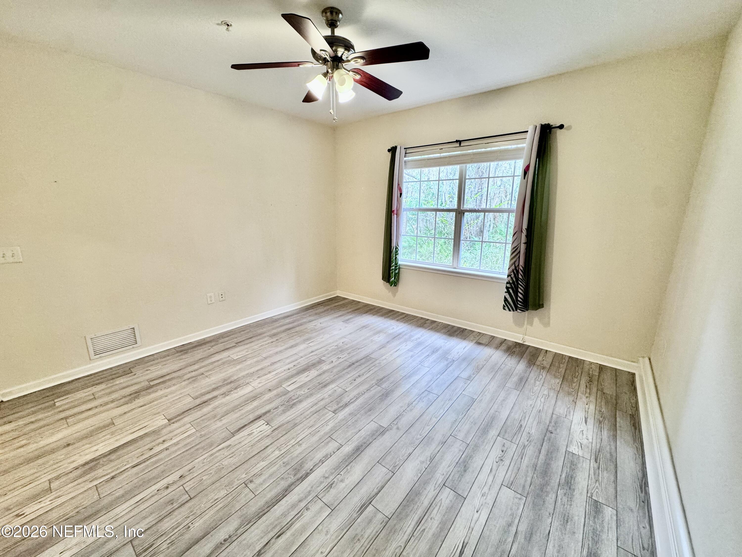 110 Magnolia Crossing Point, Unit 1903 St. Augustine, FL 32086 - Photo 11 of 31 wooden floor in an empty room with a window