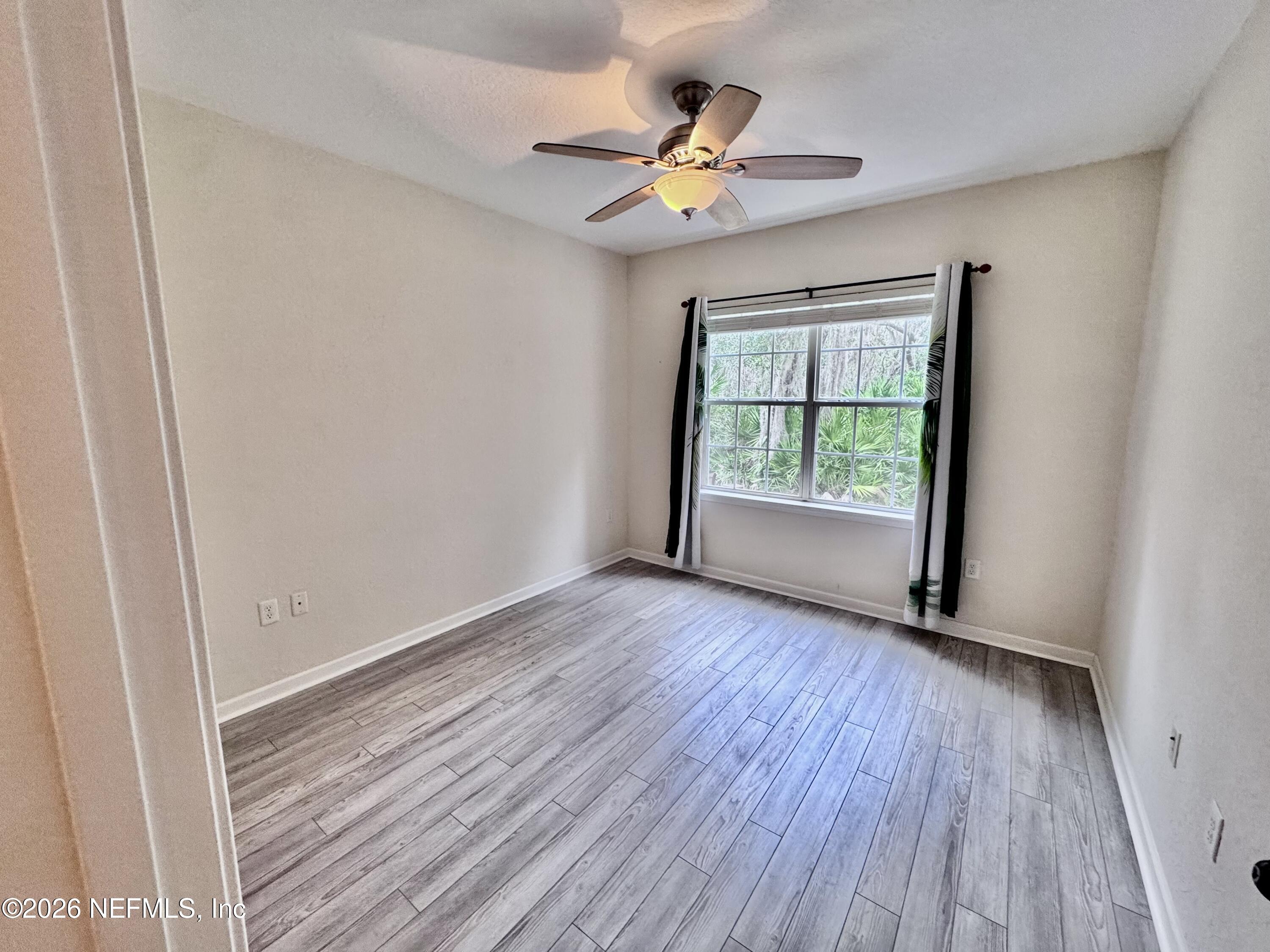 110 Magnolia Crossing Point, Unit 1903 St. Augustine, FL 32086 - Photo 12 of 26 a view of an empty room with wooden floor and a window