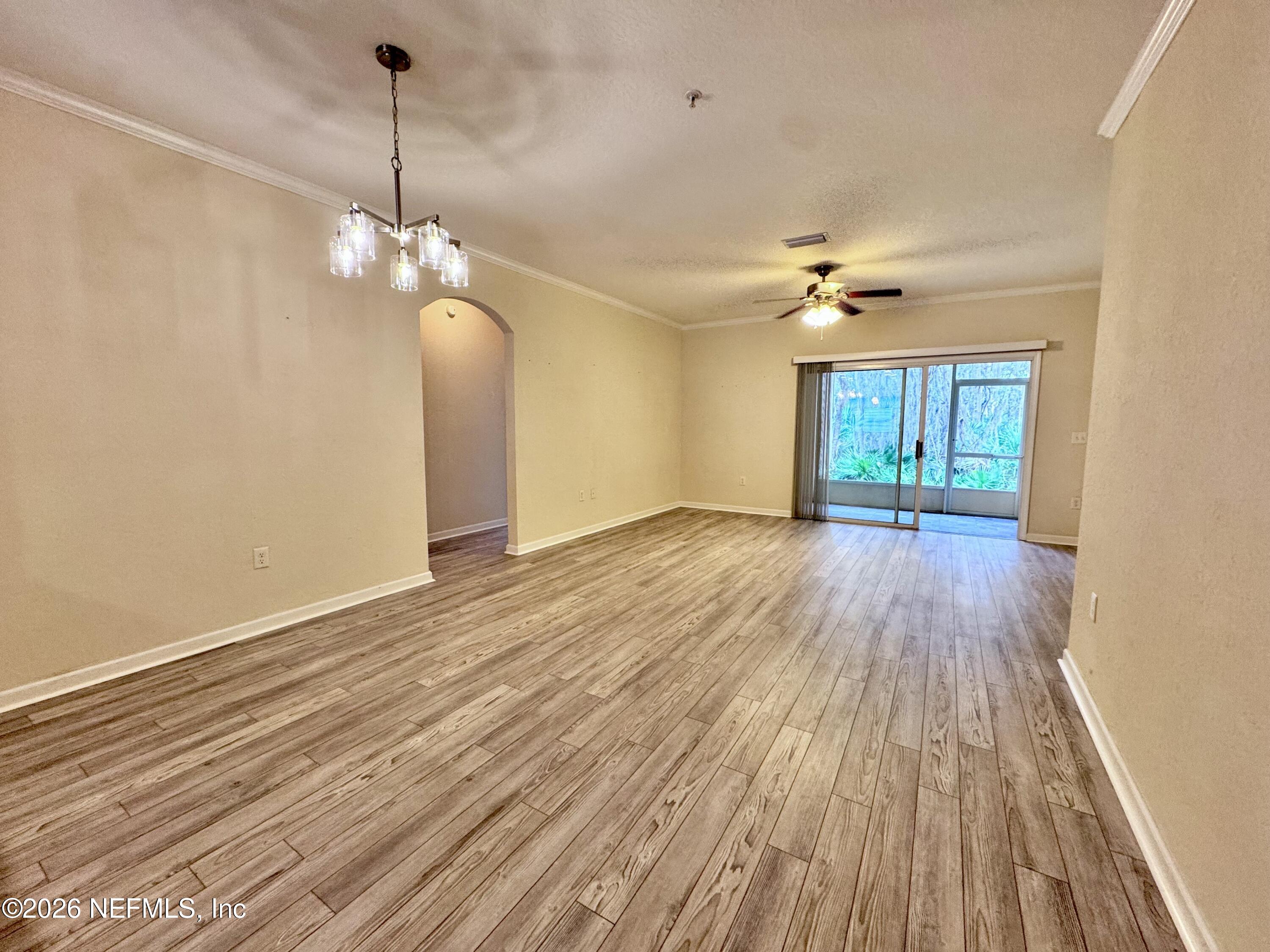 110 Magnolia Crossing Point, Unit 1903 St. Augustine, FL 32086 - Photo 4 of 26 a view of a room with a wooden floor and chandelier