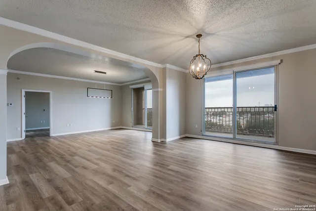 a view of a room with wooden floor and a floor to ceiling window