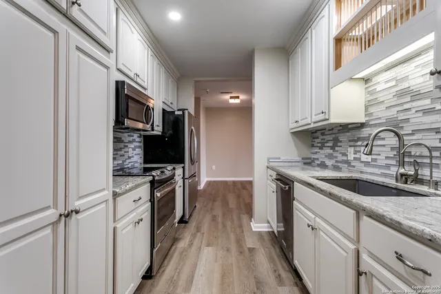a kitchen with stainless steel appliances granite countertop a sink stove and refrigerator