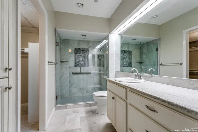 a bathroom with a granite countertop sink mirror and toilet