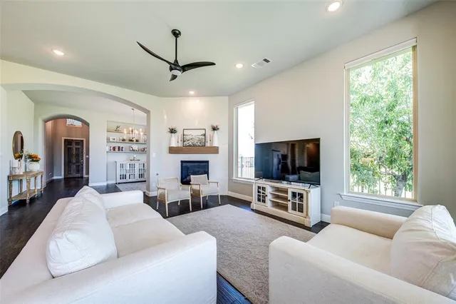 a living room with furniture a flat screen tv and a large window