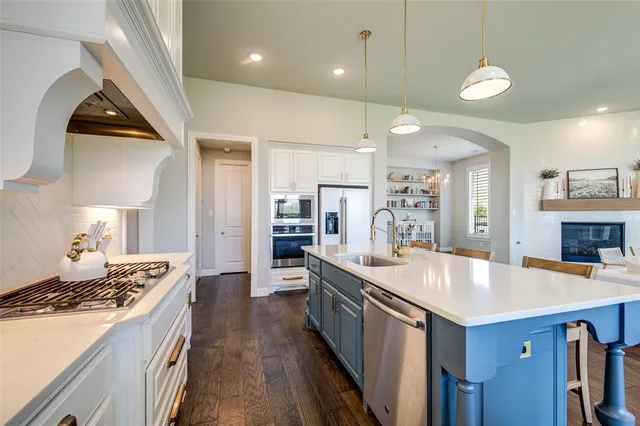 a kitchen with kitchen island a sink appliances and a counter top space