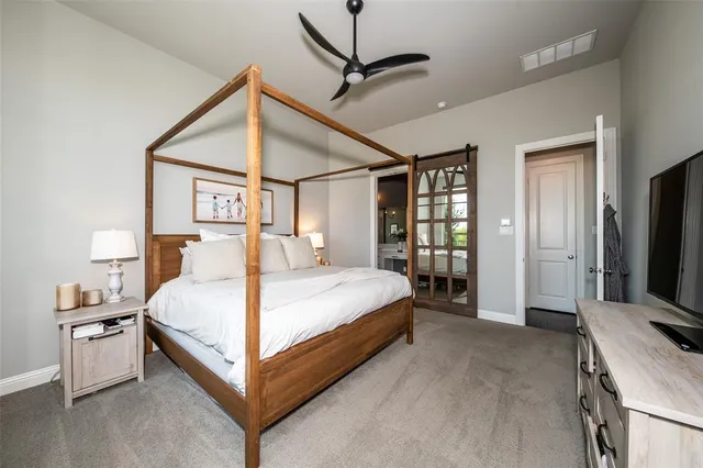 a bed room with a bed and a flat tv screen