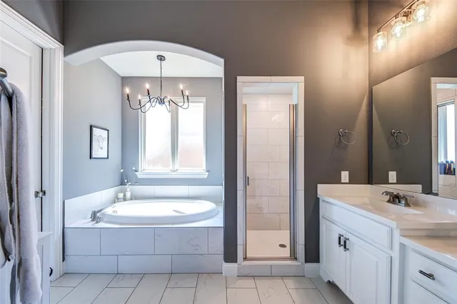 a bathroom with a tub sink shower and mirror