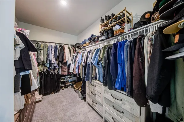a view of walk in closet with clothes and shoes