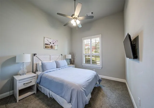 a spacious bedroom with a bed and a flat screen tv