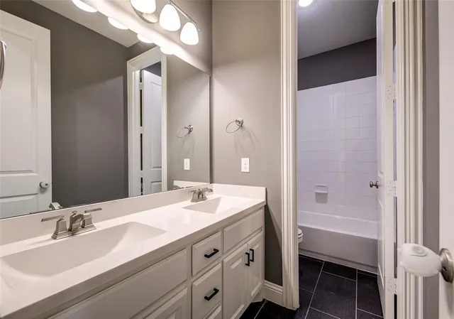 a bathroom with a sink toilet double vanity and shower