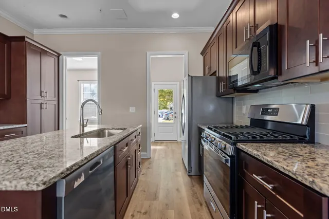 a kitchen with granite countertop stainless steel appliances and wooden cabinets