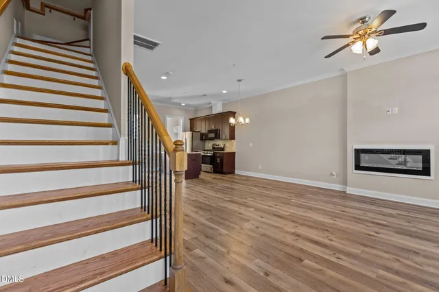 a view of a hallway with wooden floor and a ceiling fan