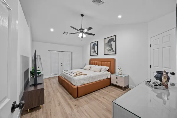 a spacious bedroom with a bed and a chandelier
