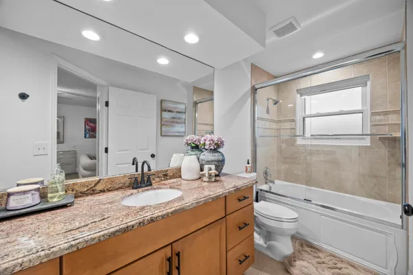 a bathroom with a granite countertop sink toilet and shower