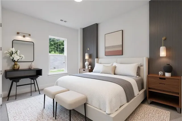 a bedroom with a bed a chair a potted plant and a window